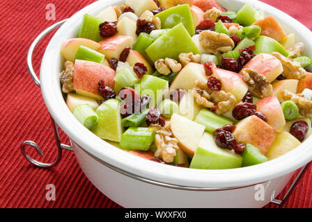 Gesunde Version von Waldorf Salat. Bestandteile sind Granny Smith und Gala Äpfel, Preiselbeeren, Sellerie, Frühlingszwiebeln, und Walnüsse. Stockfoto