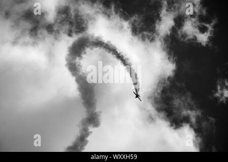 Schwarz-weiß Foto eines Flugzeugs aus der Rotorblätter, sind eine britische zivile Kunstflugstaffel der akrobatischen Manövern. Stockfoto