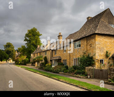 Eine Reihe von Häusern auf einer Straße in Broadway Gloucestershire England von der Straße im Sommer genommen. Stockfoto