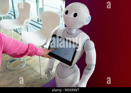 Eine Frau kommuniziert mit einem Roboter Berater Stockfoto