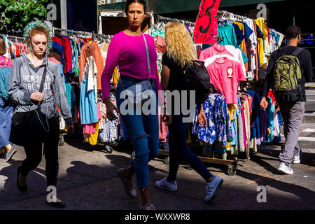 Menschen gehen vorbei an einem Straßenhändler verkaufen chinesische und andere asiatische Bekleidung am Freitag hergestellt, 13. September 2019. (© Richard B. Levine) Stockfoto