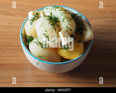 Neue Kartoffel gekocht mit frischem Dill und Butter auf hölzernen Hintergrund Stockfoto