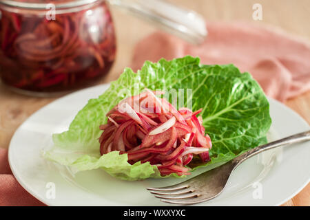 Eingelegte rote Zwiebeln in einem Glas auf hölzernen Tisch Stockfoto