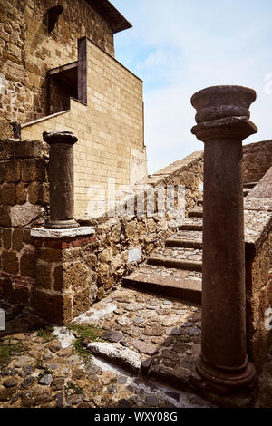 Zwei alte steinerne Säulen am Fuße einer alten Treppe in eine mittelalterliche Burg mit Mauern, in der Gemeinde von Cellere Stockfoto