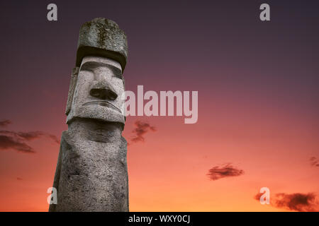 Eine antike Statue eines Moai auf der Osterinsel und die verlorene Zivilisation von Rapa Nui, mit einer romantischen und dramatischen Sonnenuntergang Himmel mit Wolken im Hinterg Stockfoto