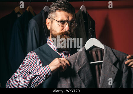 In Kontakt mit den Kunden. Bärtiger Mann nähen Jacke tailor. retro moderne Schneiderei. nähgarne Mechanisierung. Anzug store und Mode showroom Stockfoto