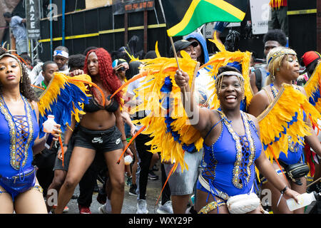 Tanzend zu lauter Musik laufen Teilnehmer der West Indian Day Parade in New York City an den Zuschauern vorbei und animieren This. Stockfoto