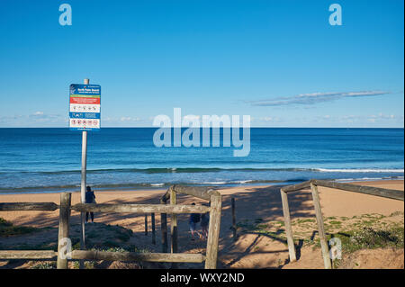 Eingang zum Palm Beach mit einem Warnschild an einem sonnigen Tag mit einem klaren blauen Himmel, New South Wales, Australien Stockfoto