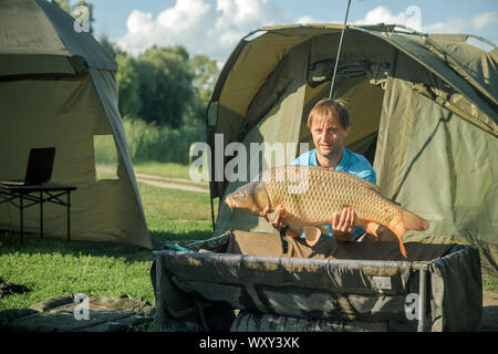 Glückliche Angler mit Karpfen angeln Trophäe Stockfoto