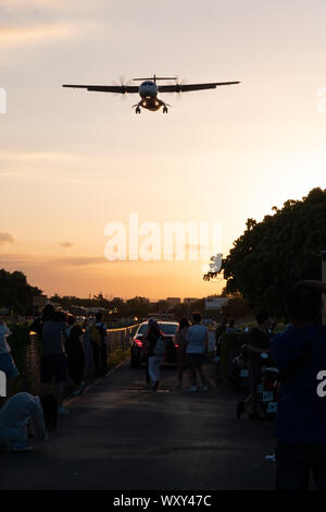 Zuschauer verfolgen und Fotos von "Flugzeug Alley" wie ein Flugzeug der Flughafen Taipei Songshan macht bei Sonnenuntergang Stockfoto