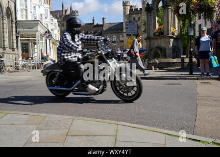 Ein Mann, der seine Harley Davidson Sportster auf der Hohen Straße in Wells, Somerset Stockfoto