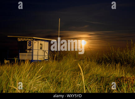 Mondaufgang am Meer von Usedom, Deutschland. Im Vordergrund sehen Sie Cottage der Rettungsschwimmer. Stockfoto