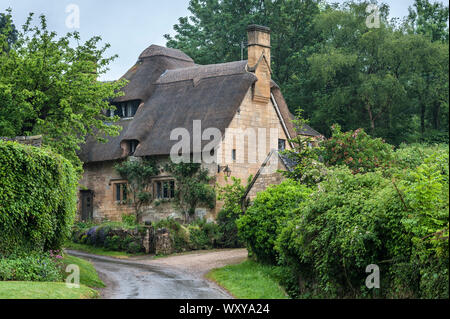 Reetdachhaus in dem Dorf Stanton, Cotswolds Bezirk von Gloucestershire. Es ist mit einem Honigfarbenen Jura Kalkstein gebaut Stockfoto