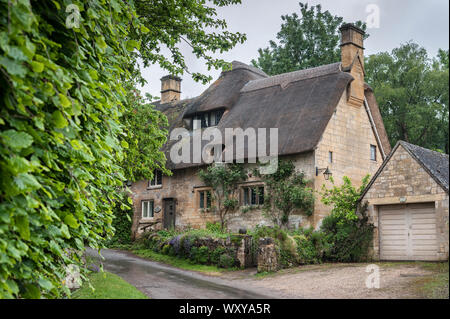 Reetdachhaus in dem Dorf Stanton, Cotswolds Bezirk von Gloucestershire. Es ist mit einem Honigfarbenen Jura Kalkstein gebaut Stockfoto