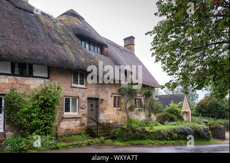 Reetdachhaus in dem Dorf Stanton, Cotswolds Bezirk von Gloucestershire. Es ist mit einem Honigfarbenen Jura Kalkstein gebaut Stockfoto