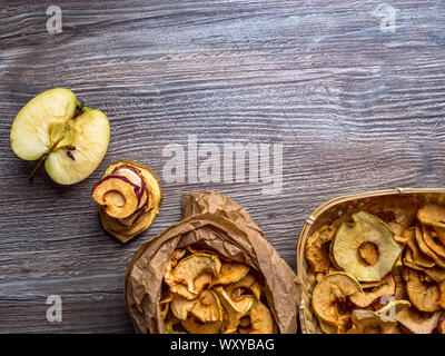 Hausgemachte sonnengetrockneten Bio Apfelscheiben, Crispy apple Chips, auf hölzernen Hintergrund und frischen Apfel. Platz kopieren Stockfoto