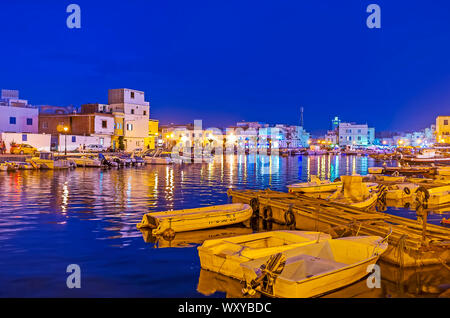 Bizerta, Tunesien - September 4, 2015: Beobachten Sie den Abend Stadt vom Hafen mit vielen günstig Fischerboote und die hellen Lichter der Stadt, auf dem Wasser spiegelt sich s Stockfoto