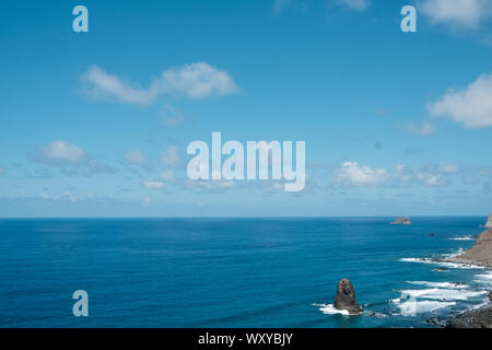 Blauer Himmel über Ocean Horizon auf sonnigen Sommertag an der felsigen Küste Stockfoto