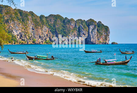 AO NANG, Thailand - 25 april 2019: Traditionelle Longtail Boote sind auf die Flutwelle an der Küste von Resort, am 25. April in Ao Nang Stockfoto