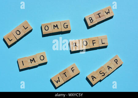 Internet Slang. Abkürzungen: BTW (Übrigens), OMG, LOL, WTF, ROFL, und IMO als Abkürzungen in SMS-Nachrichten verwendet, in Holz- Alphabet Buchstaben auf blauem Stockfoto