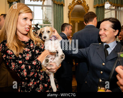 Die Partnerin von Premierminister Boris Johnson, Carrie Symonds (links), stellt den Gästen Dilyn, den Jack Russell, ihren Hund, vor, während der Premierminister einen Militärempfang in der Downing Street 10, London, veranstaltet. Stockfoto