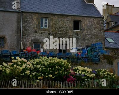 Maison bretonne Fleurie d'Hortensias avec des accessoires de Peche au crustacés, toit de Ardoise, casier De Peche, Le Conquet, Bretagne Stockfoto