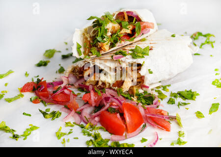 Frische Hähnchen shawerma mit Gemüse, grünen und speziellen Sauce auf weißem Papier Stockfoto