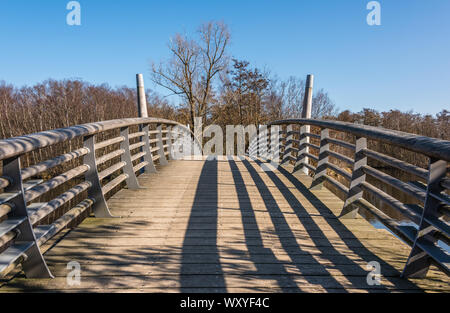 Herbst Szene mit rot gelb braun und orange Farben den Wechsel der Jahreszeiten mit hölzernen Brücke mit Geländer stahl Brücke über Wasser im Herbst Szene wit Stockfoto