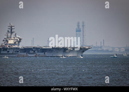 Der Flugzeugträger USS Ronald Reagan ist durch japanische Fischerboote auf dem Weg zum Meer von Kamakura, Japan. Stockfoto