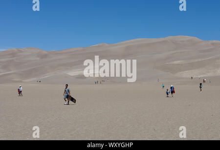 Wanderer und Sand sledders den Dünen am Great Sand Dunes National Park Klettern im Sommer in Colorado. Stockfoto