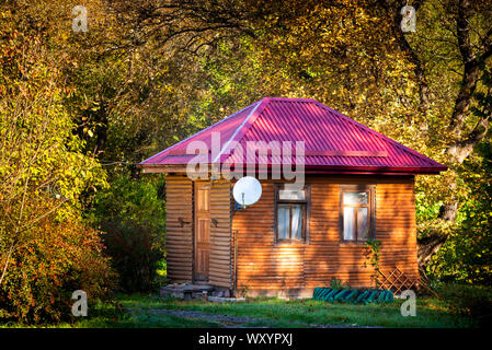Ferienwohnung - Ferienhaus aus Holz im Wald im frühen Herbst. Stockfoto