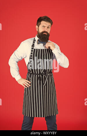 Arbeit Süchtiger. Hipster tragen elegante Arbeit einheitlich. Koch oder Barkeeper routinemäßige Arbeit in Restaurant Bar oder in der Küche. Bärtiger Mann in Bow Tie und Schürze. Tägliche Arbeitsabläufe und Aktivitäten. Stockfoto