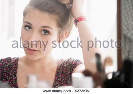 Teenager-Mädchen Blick auf ihr Spiegelbild in den Spiegel Stockfoto