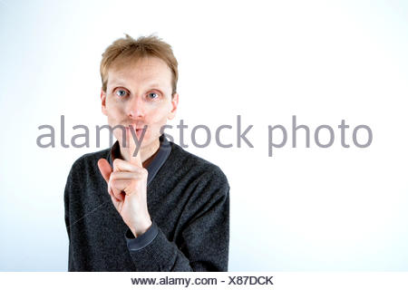 Blonden Mann, der seinen Finger an der Mündung
