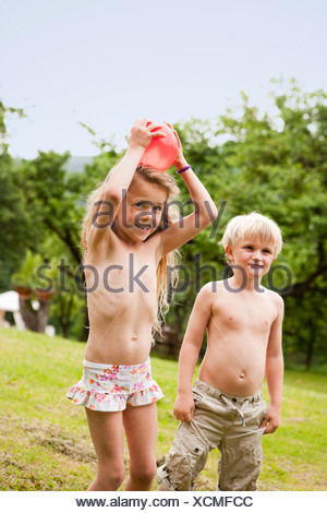 Mädchen und Jungen spielen mit Wasser im Garten Stockfotografie - Alamy