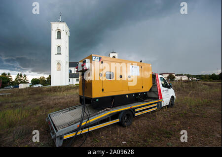 El generador de energía eléctrica de emergencia utilizado durante un tiempo tormentoso en Pultusk, Polonia, para suministrar electricidad a una comunidad con la iglesia y un hospital. Foto de stock