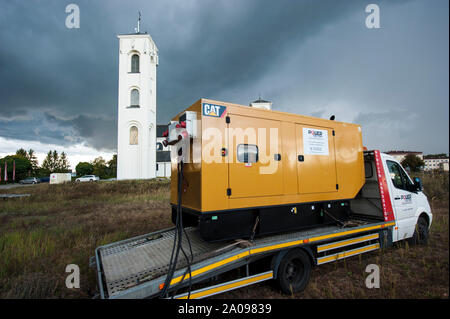 El generador de energía eléctrica de emergencia utilizado durante un tiempo tormentoso en Pultusk, Polonia, para suministrar electricidad a una comunidad con la iglesia y un hospital. Foto de stock
