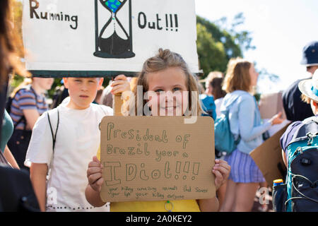 Un joven manifestante con un mensaje para el presidente de Brasil durante una protesta en Cardiff, exigiendo la acción sobre el cambio climático, parte de una juventud global st