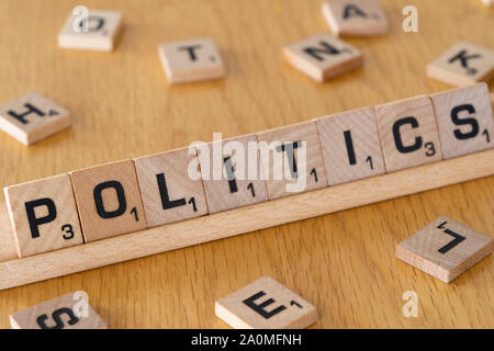 Letras de Scrabble en madera en un estante de deletrear la palabra política