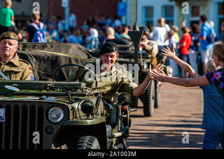 Una mujer ropa militar da cinco a un niño durante el desfile. Desfile de vehículos militares conmemorando 75 años que se a cabo la operación Market Garden. Operation Market