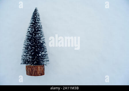 Pequeño árbol de navidad artificial en la nieve. Foto de stock