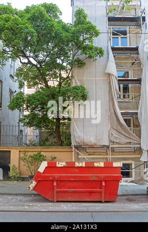 Contenedor rojo grande en el sitio de construcción saltar en la ciudad Foto de stock