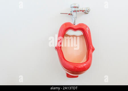 Un labios rojos orinal con dientes blancos en el baño para hombres en el coleccionista coche Vault en Santa Paula, California. El urinal fue originalmente diseñado en Foto de stock