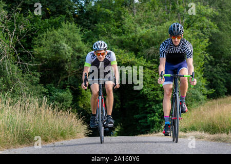 Triatletas montando bicicleta en country road, Alemania Foto de stock