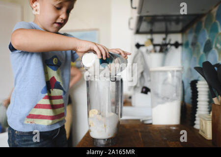 Boy cocinar panqueques de banana en cocina en casa Foto de stock