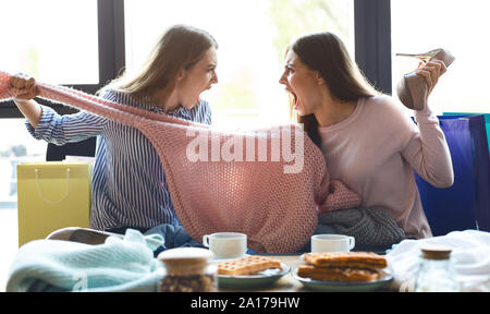 Dos chicas luchando por el suéter rosa y gritando en cada otros Foto de stock