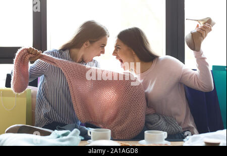 Dos niñas argumentando sobre sweater que han comprado Foto de stock