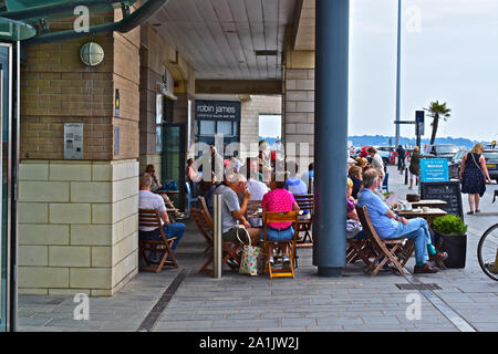 Las personas sentarse fuera y disfrutar de una bebida en el Café con vistas a Quay Poole Harbour. Foto de stock