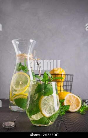 Agua infundida con limón y menta en el cristal. Cerca. Detox saludable bebida para mañana. Foto de stock