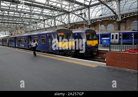 Los pasajeros que abordan Scotrail Clase 320 trenes eléctricos en la Estación Central de Glasgow Foto de stock